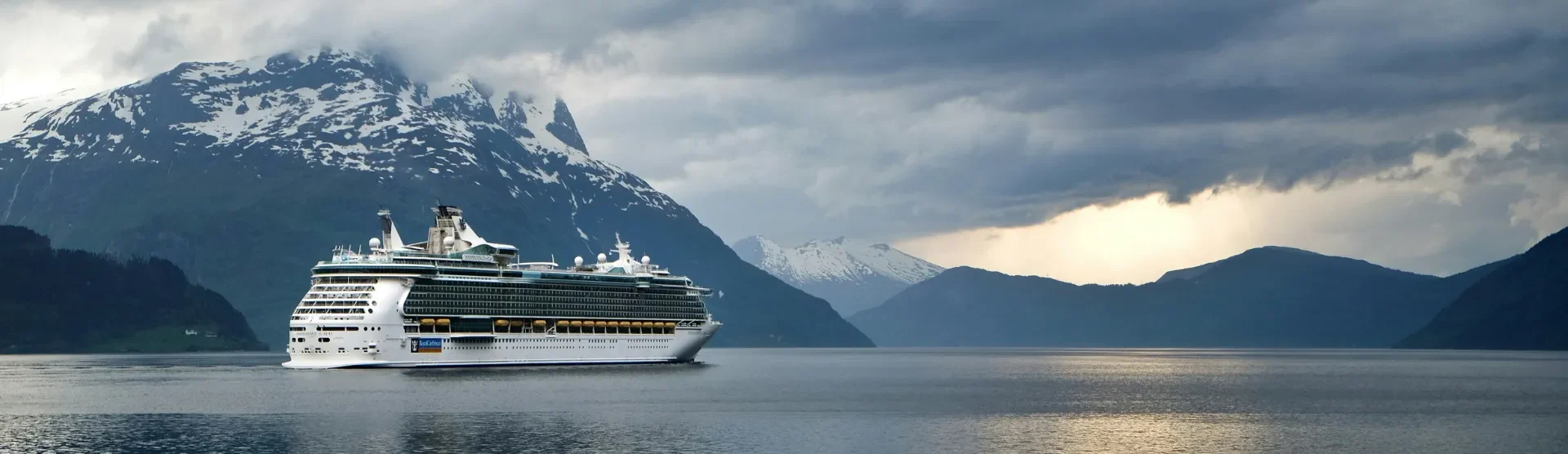 Schiff auf Meer vor einem Berg mit Schnee